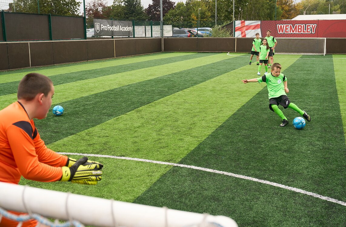 boys playing football shooting at goal