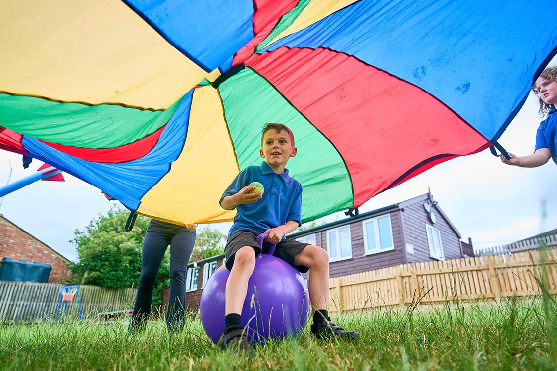 child on space hoppper under a coloured canopy