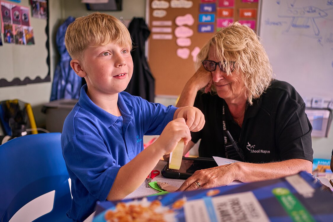 child with adult doing school work