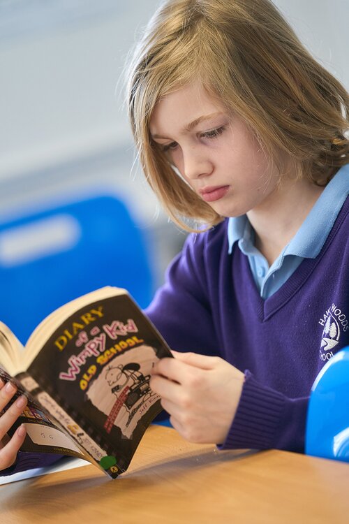 child in school uniform reading