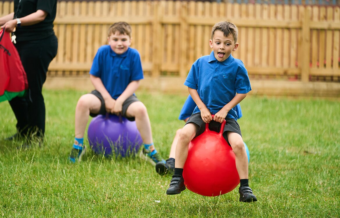 two children racing on space hoppers