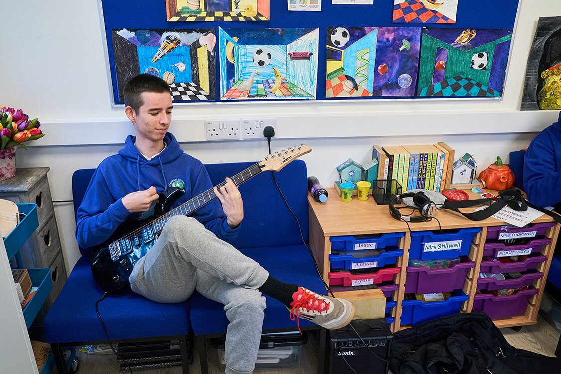 pupil sat playing electric guitar