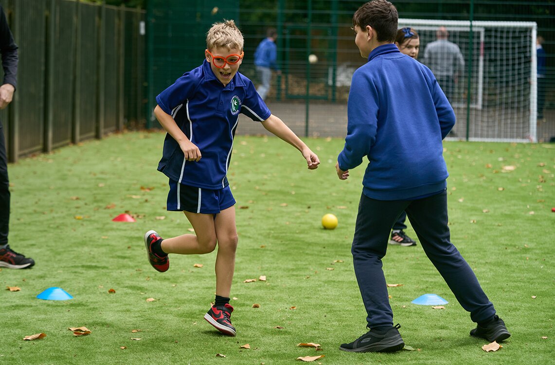children in pe kit running outdoors