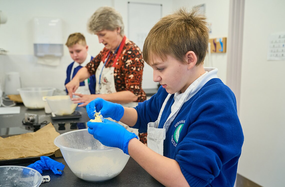 child breaking up butter into a mixing bowl