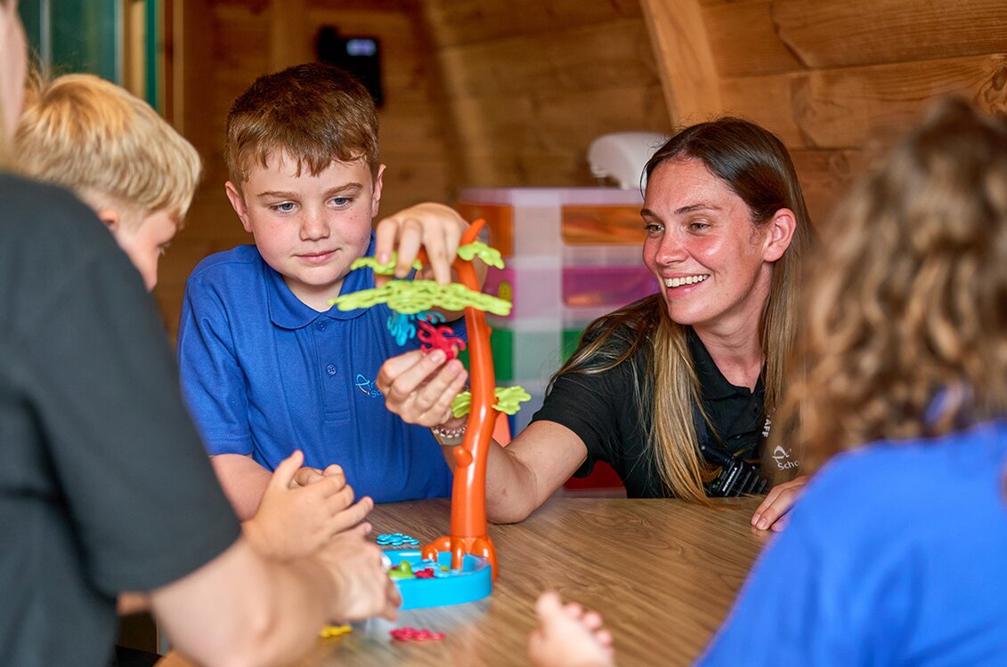 two children and adults play a game