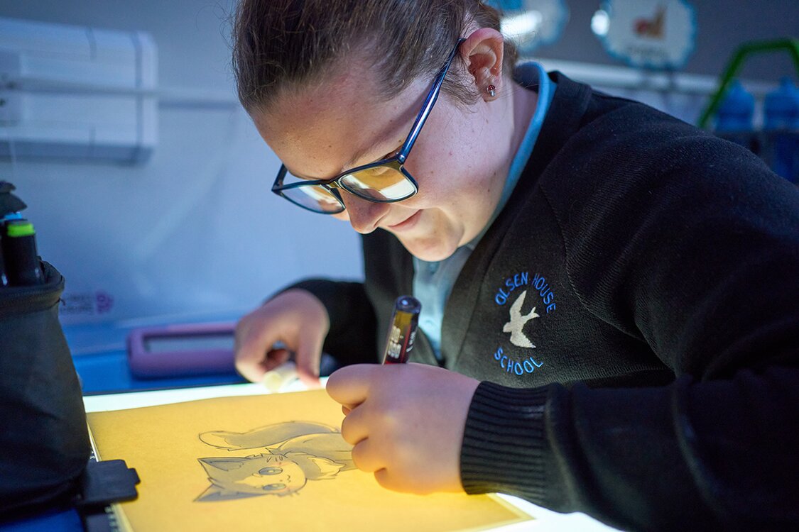 child draws on a lightbox
