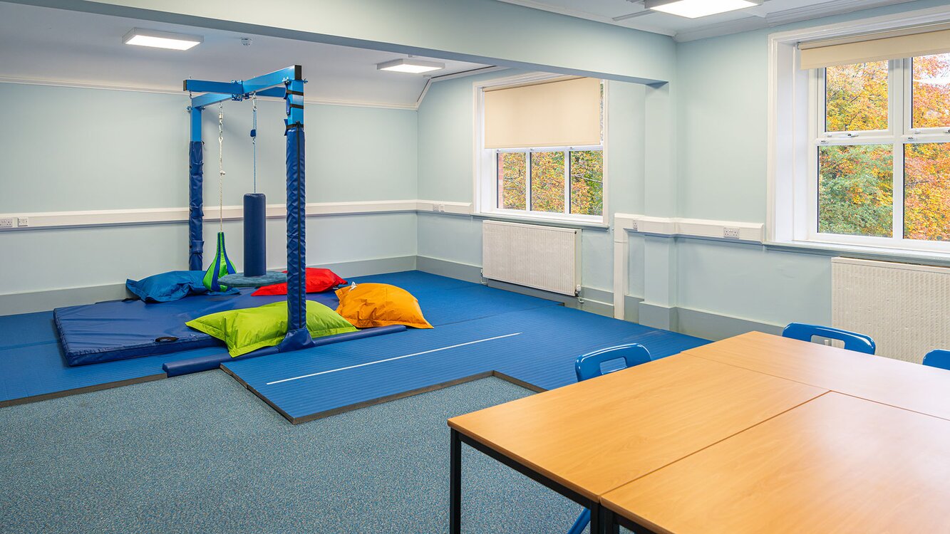 therapy room shows colourful matting and a swing indoors