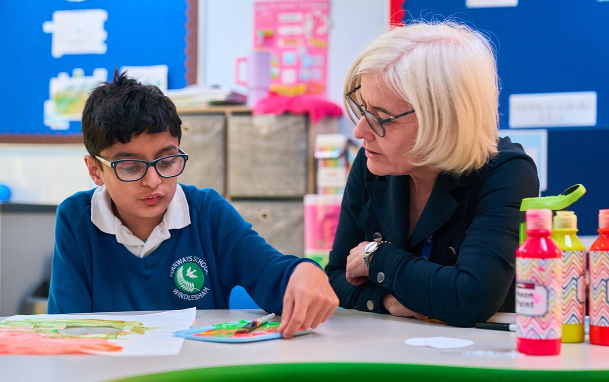 pupil painting watched by adult