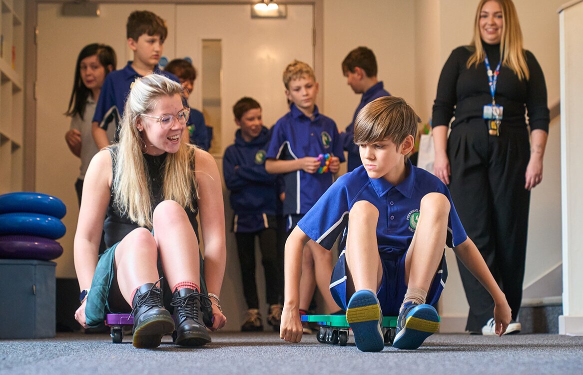 a child and adult racing on wheeled sleds indoors