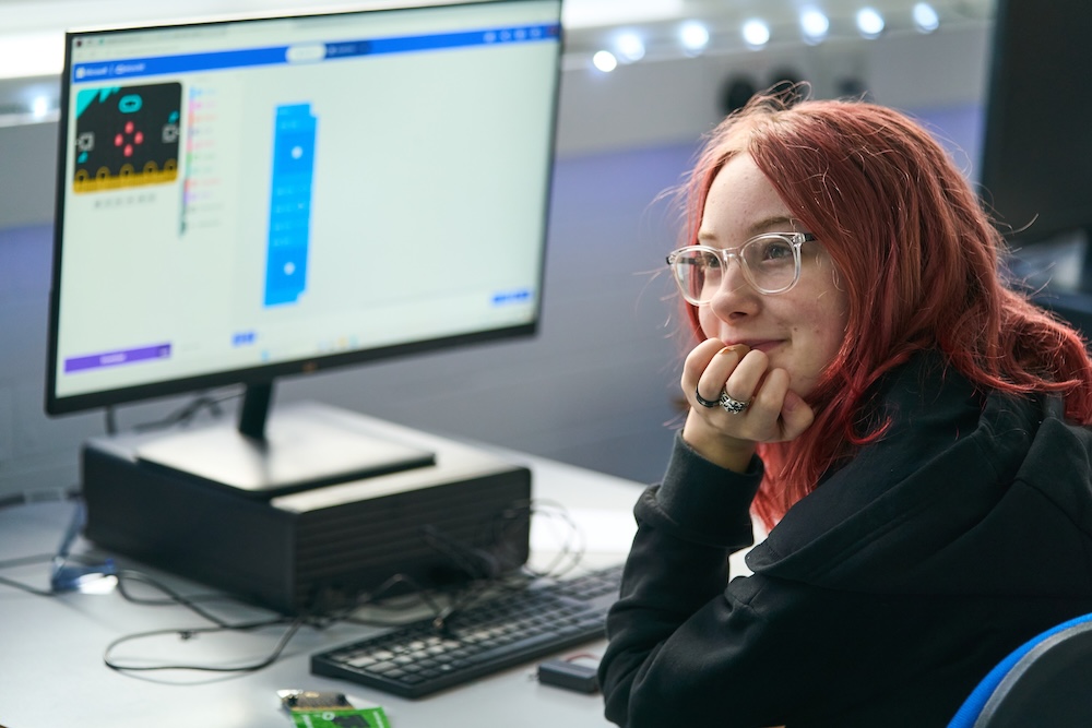 student smiling working on computer