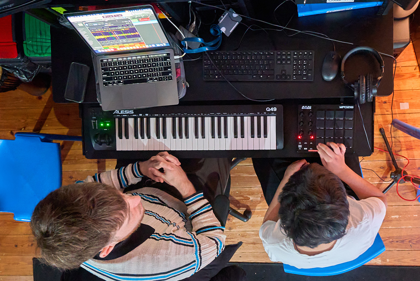 Overhead view of a pupil and an adult using a musical §keyboard