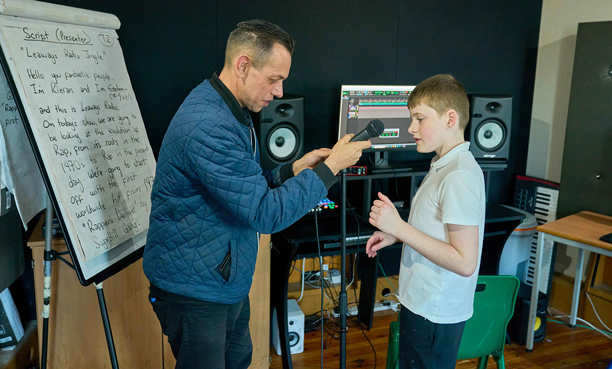 child and adult setting up a microphone stand