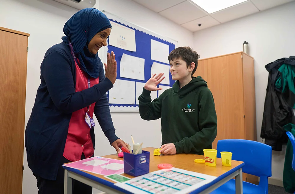 Pupil and staff member high five