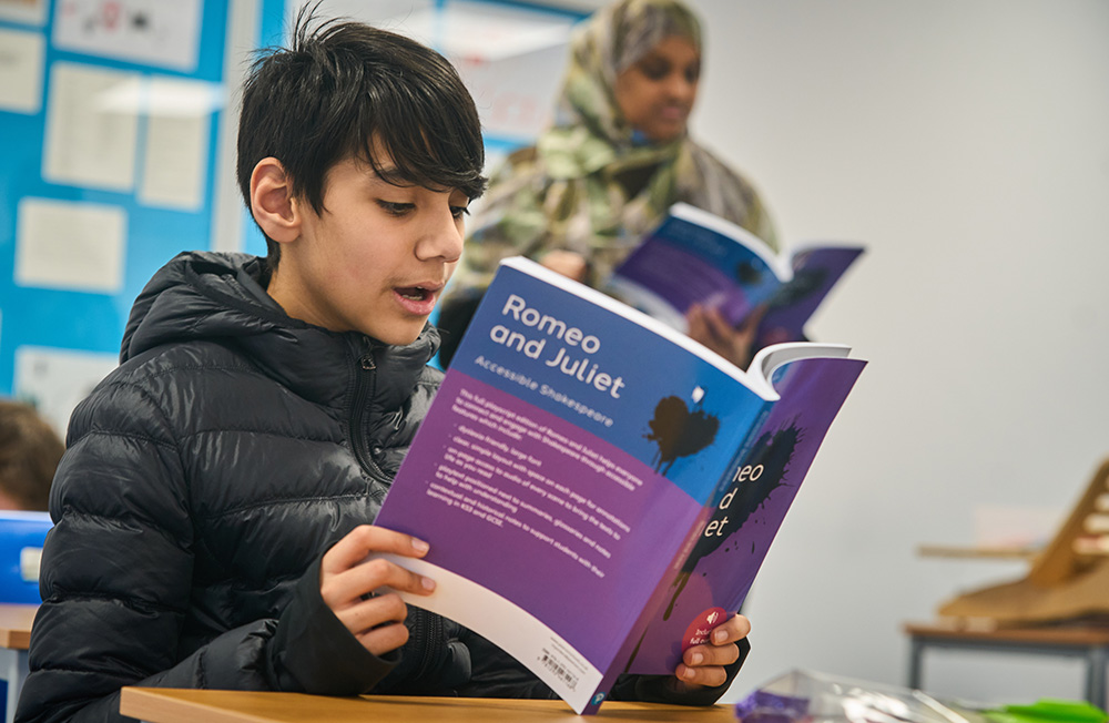 pupil reading Romeo and Juliet sat and desk