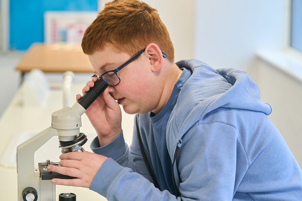 pupil looking into a microscope