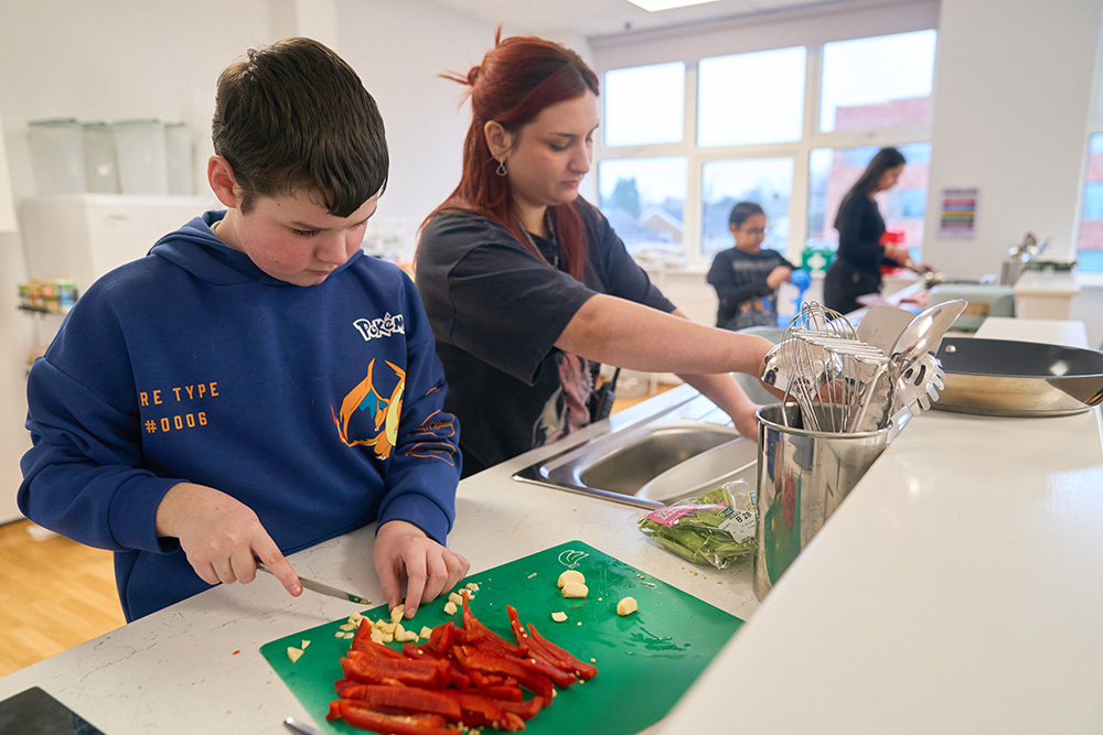 pupil chipping garlic and peppers in a food tech lesson