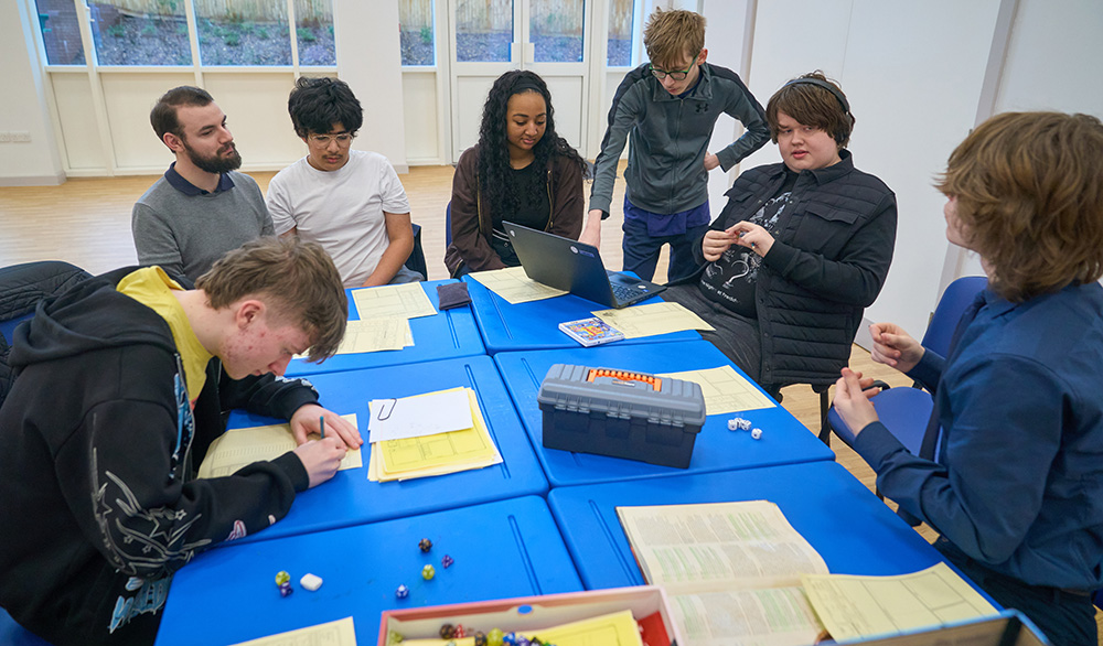 a group of pupils around a table playing dungeons and dragons