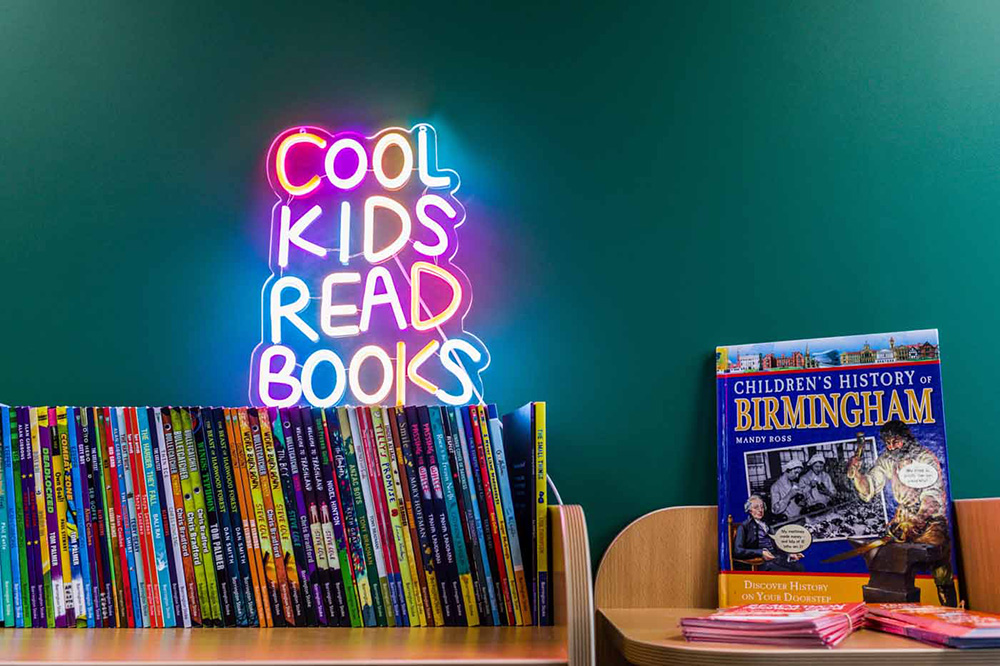 neon sign and row of books in library